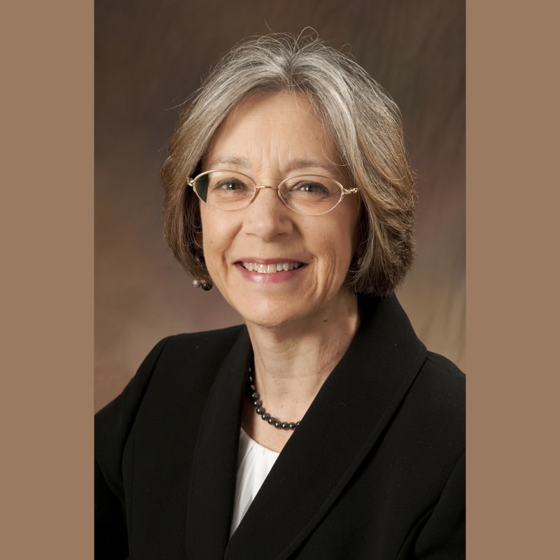 May contain a person wearing a black blazer and glasses.