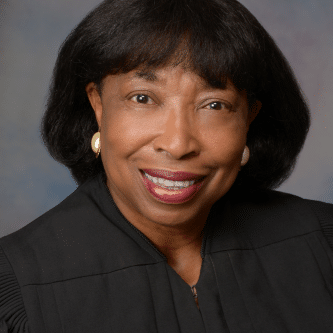 May contain one person in judicial robes and earrings.