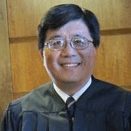 May contain a person wearing a judicial robe and glasses.