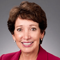 May contain one person, a person smiling, wearing a red blazer.