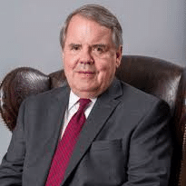 May contain one person in a suit and tie sitting in a leather chair.