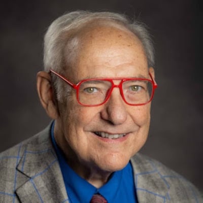 May contain one person wearing red glasses and a plaid jacket.