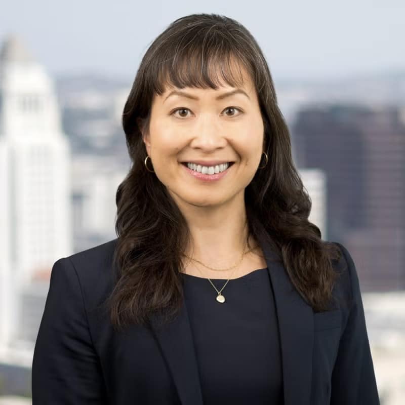 May contain one person wearing a suit jacket and necklace.