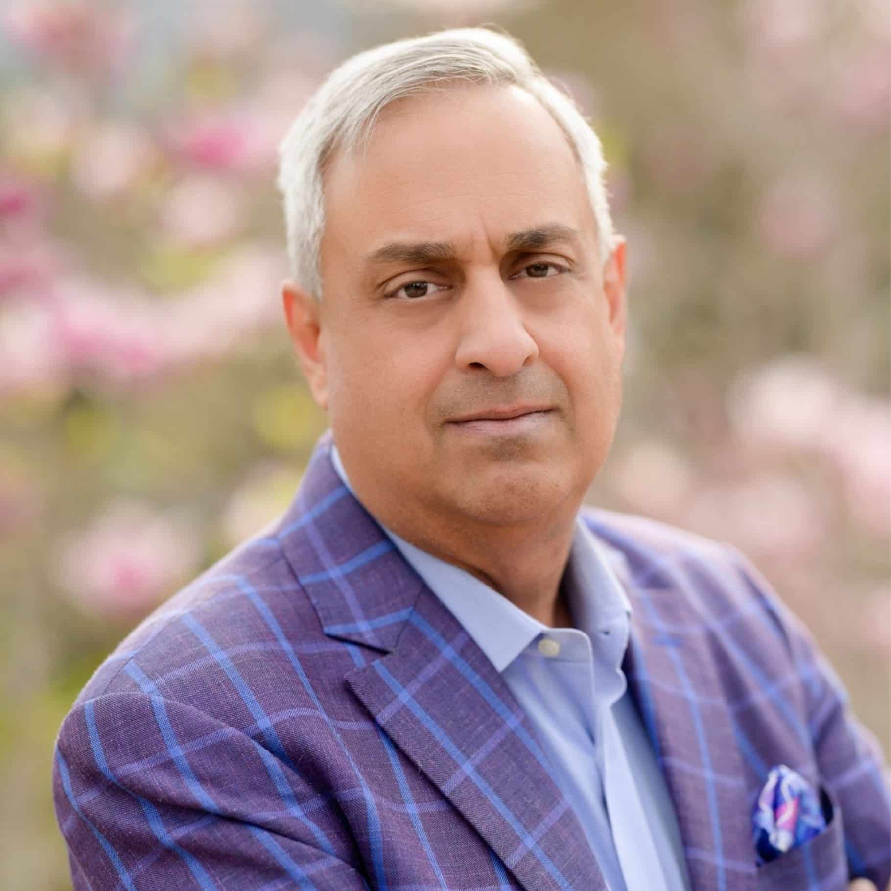 May contain one person wearing a purple plaid jacket and a blue shirt.