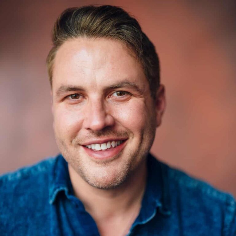 May contain one person smiling, wearing a denim shirt.