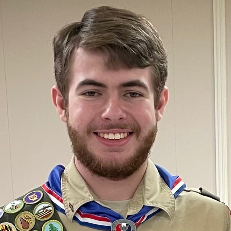 May contain one person in a scout uniform smiling at the camera.