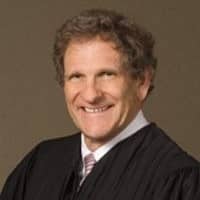 May contain a person in a judicial robe smiling.