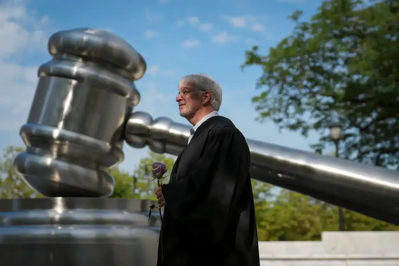 May contain one person in a black robe holding a purple rose.