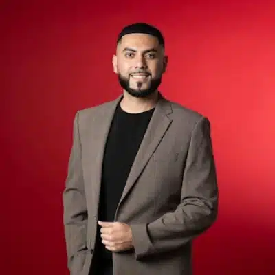 May contain one person wearing a brown suit jacket over a black shirt.