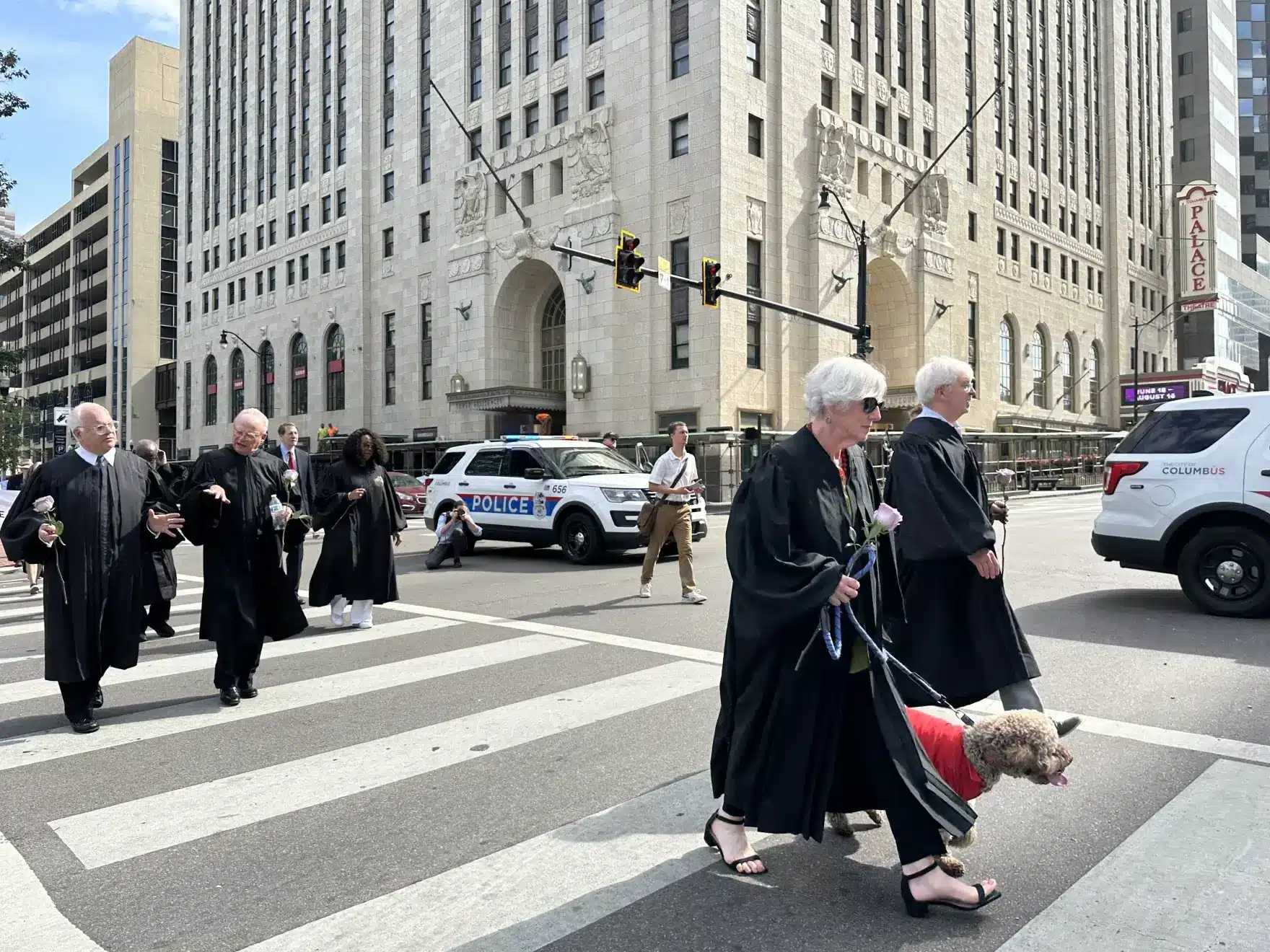 May contain a person walking a dog on a leash, while wearing a robe.
