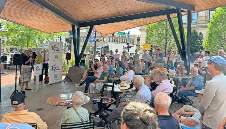 May contain people gathered for an outdoor event under a wooden roof.