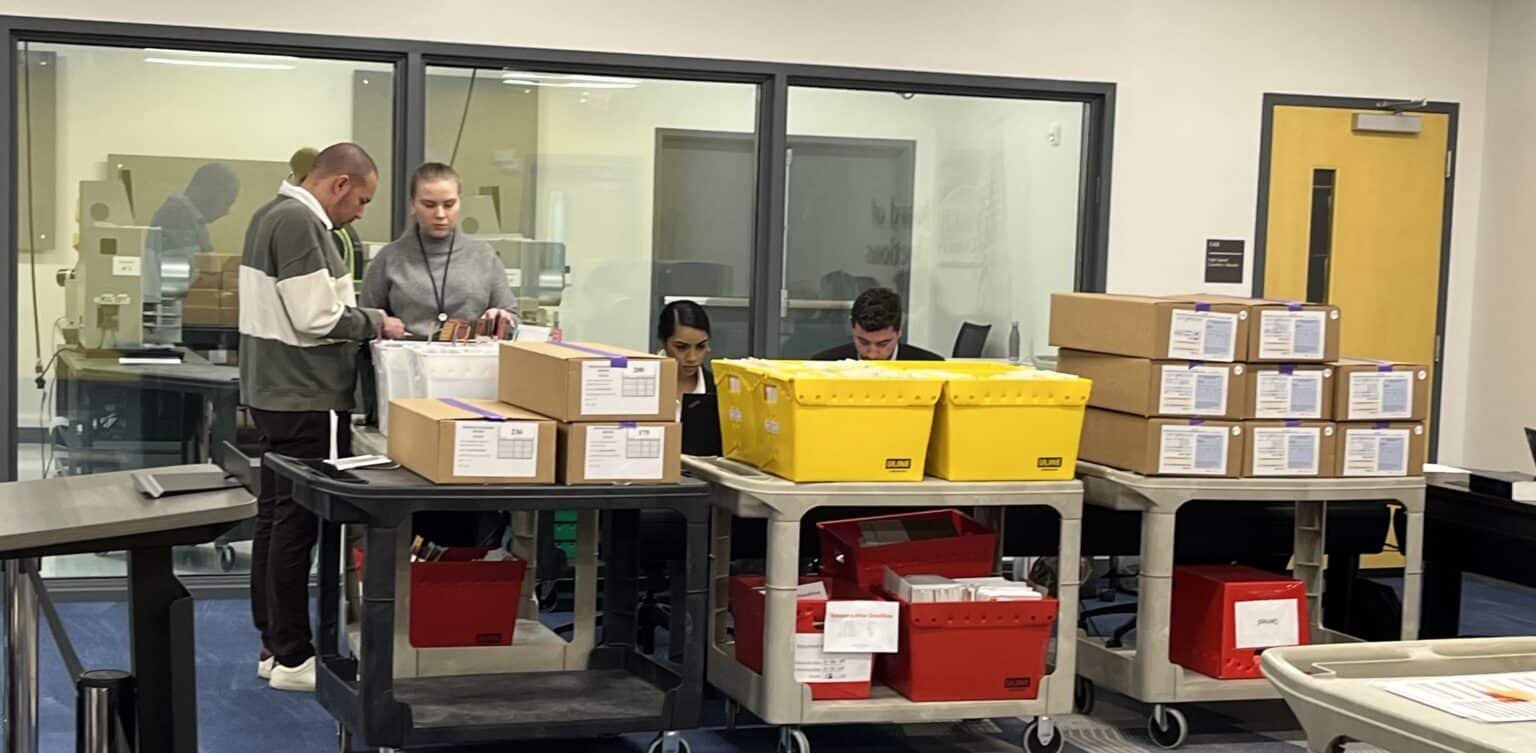 May contain four people working with boxes and bins.