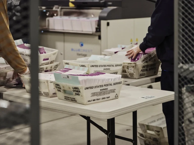 May contain two people handling mail trays.