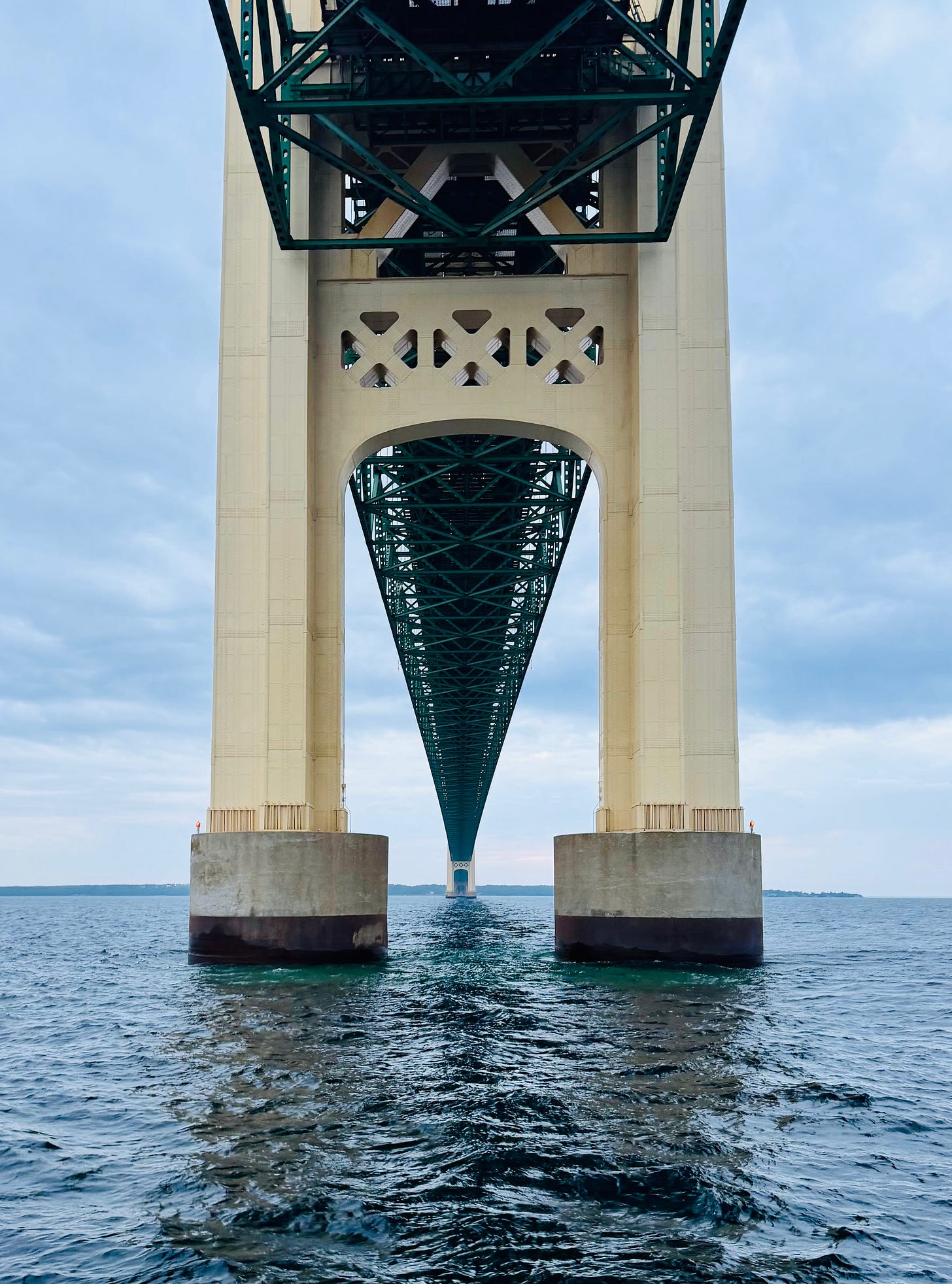 May contain a person standing on a bridge pier overlooking the water.