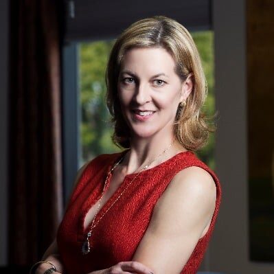 May contain one person smiling, wearing a red dress and necklace.