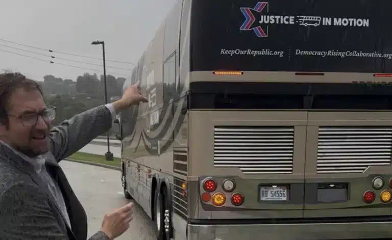 May contain one person pointing at a bus with "Justice in Motion" logo.