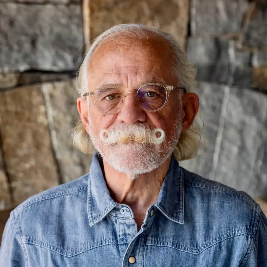 May contain one person wearing glasses and a denim shirt.