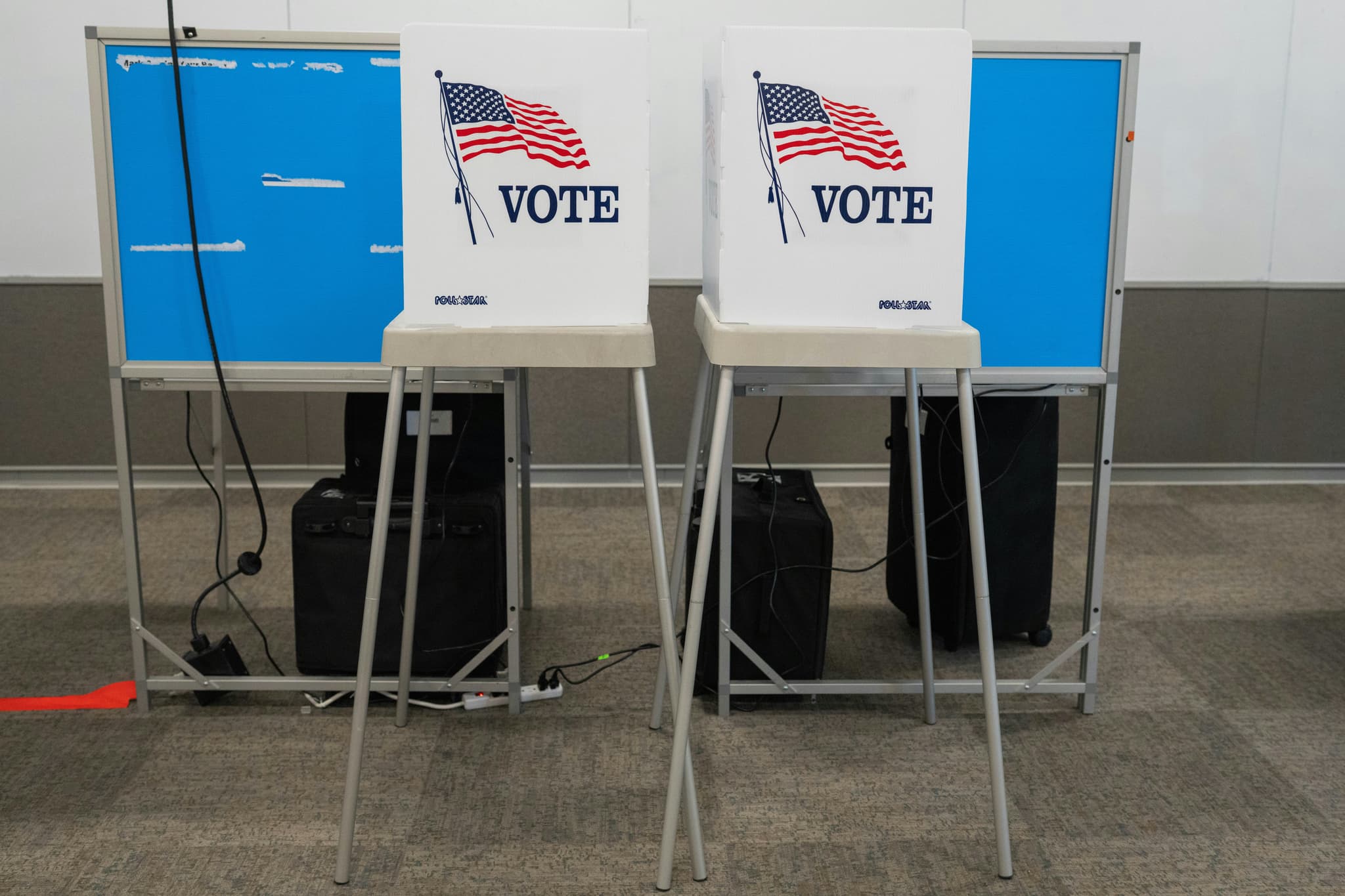 May contain two voting booths with American flags and the word "VOTE".